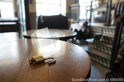 Image of Public institutions closed due to COVID-19 or Coronavirus outbreak lockdown, stressed owner of small business alone in his cafe, focus on door lock