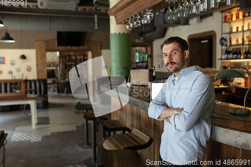 Image of Public institutions closed due to COVID-19 or Coronavirus outbreak lockdown, stressed owner of small business alone in his cafe, restaurant, bar