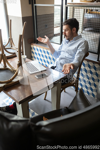 Image of Public institutions closed due to COVID-19 or Coronavirus outbreak lockdown, stressed owner of small business alone in his cafe, looking for solution