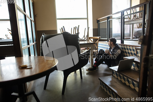 Image of Public institutions closed due to COVID-19 or Coronavirus outbreak lockdown, stressed owner of small business alone in his cafe, restaurant, bar