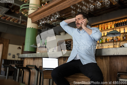 Image of Restaurant, cafe, bar closed due to COVID-19 or Coronavirus outbreak lockdown, stressed owner of small business trying to find solution