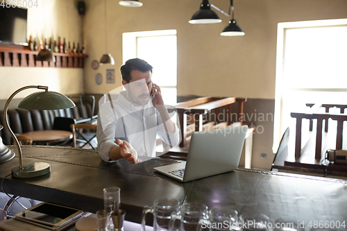 Image of Restaurant, cafe, bar closed due to COVID-19 or Coronavirus outbreak lockdown, stressed owner of small business trying to find solution