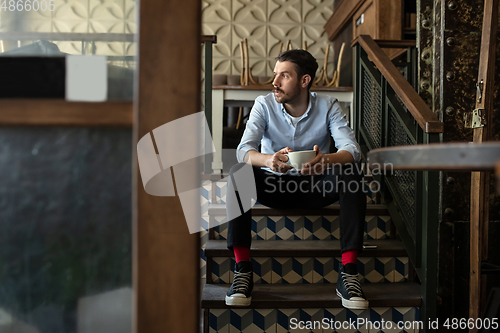 Image of Public institutions closed due to COVID-19 or Coronavirus outbreak lockdown, stressed owner of small business alone in his cafe, despair