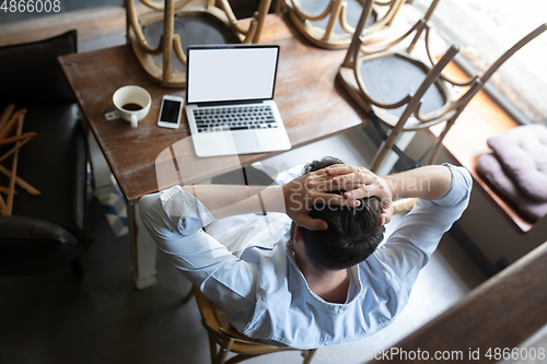 Image of Restaurant, cafe, bar closed due to COVID-19 or Coronavirus outbreak lockdown, stressed owner of small business trying to find solution, top view