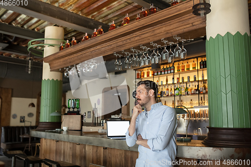 Image of Public institutions closed due to COVID-19 or Coronavirus outbreak lockdown, stressed owner of small business alone in his cafe, restaurant, bar