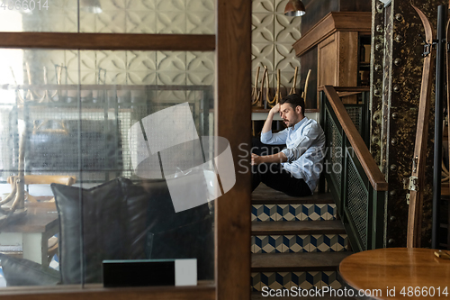 Image of Public institutions closed due to COVID-19 or Coronavirus outbreak lockdown, stressed owner of small business alone in his cafe, restaurant, bar