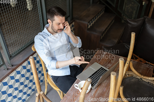 Image of Public institutions closed due to COVID-19 or Coronavirus outbreak lockdown, stressed owner of small business alone in his cafe, looking for solution