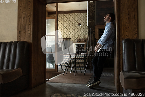 Image of Public institutions closed due to COVID-19 or Coronavirus outbreak lockdown, stressed owner of small business alone in his cafe, despair