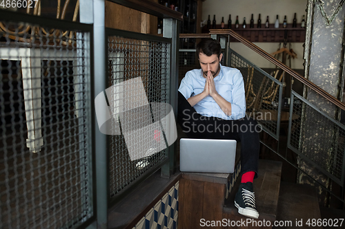 Image of Public institutions closed due to COVID-19 or Coronavirus outbreak lockdown, stressed owner of small business alone in his cafe, restaurant, bar