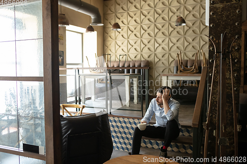 Image of Public institutions closed due to COVID-19 or Coronavirus outbreak lockdown, stressed owner of small business alone in his cafe, despair