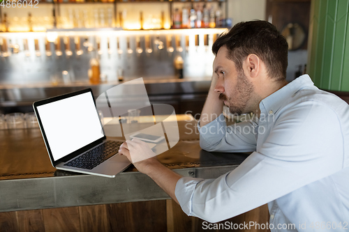 Image of Restaurant, cafe, bar closed due to COVID-19 or Coronavirus outbreak lockdown, stressed owner of small business trying to find solution