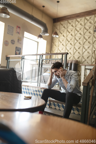 Image of Restaurant, cafe, bar closed due to COVID-19 or Coronavirus outbreak lockdown, stressed owner of small business trying to find solution, need help