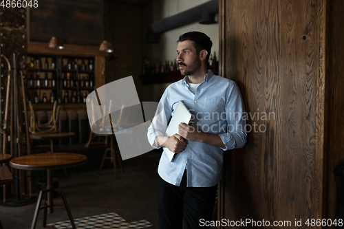 Image of Public institutions closed due to COVID-19 or Coronavirus outbreak lockdown, stressed owner of small business alone in his cafe, despair