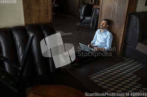 Image of Public institutions closed due to COVID-19 or Coronavirus outbreak lockdown, stressed owner of small business alone in his cafe, despair lying down the floor