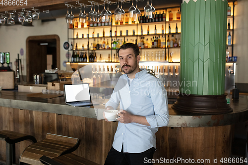 Image of Public institutions closed due to COVID-19 or Coronavirus outbreak lockdown, stressed owner of small business alone in his cafe, restaurant, bar