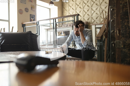 Image of Public institutions closed due to COVID-19 or Coronavirus outbreak lockdown, stressed owner of small business alone in his cafe, despair