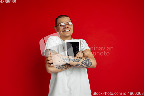 Image of Caucasian young man\'s portrait on red studio background with copyspace - emotional and expressive