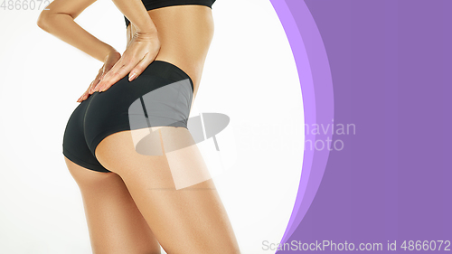 Image of Beautiful female legs and buttocks on white and purple background. Beauty, cosmetics, spa, depilation, treatment and fitness concept, sensual posing. Flyer