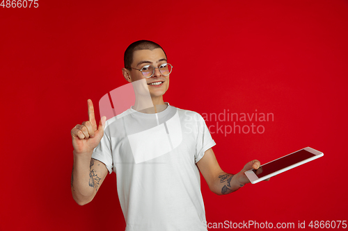Image of Caucasian young man\'s portrait on red studio background with copyspace - emotional and expressive