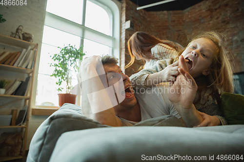 Image of Family spending nice time together at home, looks happy and cheerful, lying down together