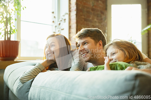 Image of Family spending nice time together at home, looks happy and cheerful, lying down together