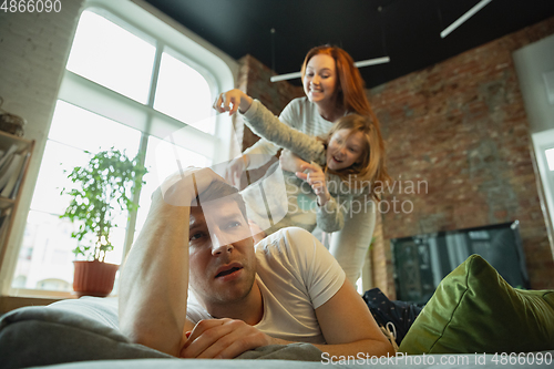 Image of Family spending nice time together at home, looks happy and cheerful, fighting with pillows