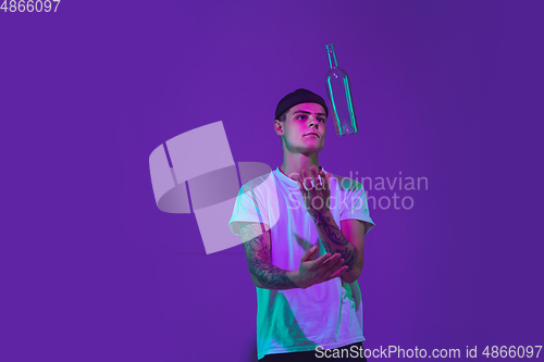 Image of Caucasian man\'s portrait isolated on purple studio background in neon light