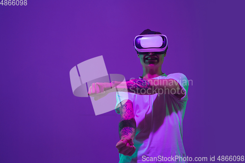 Image of Caucasian man\'s portrait isolated on purple studio background in neon light