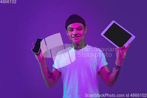 Image of Caucasian man\'s portrait isolated on purple studio background in neon light