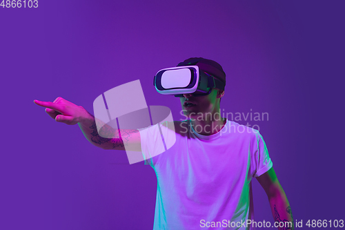 Image of Caucasian man\'s portrait isolated on purple studio background in neon light