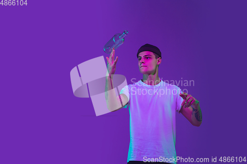 Image of Caucasian man\'s portrait isolated on purple studio background in neon light