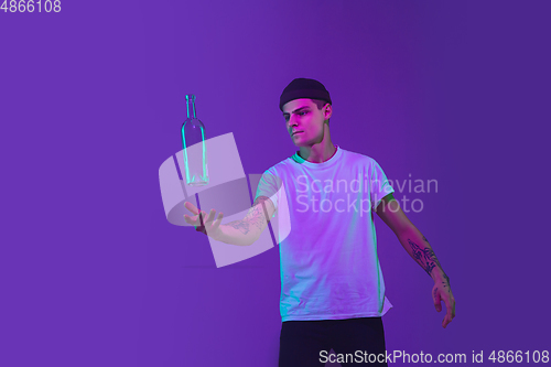 Image of Caucasian man\'s portrait isolated on purple studio background in neon light