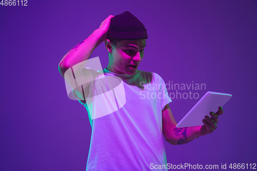 Image of Caucasian man\'s portrait isolated on purple studio background in neon light