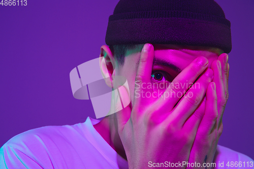 Image of Caucasian man\'s portrait isolated on purple studio background in neon light