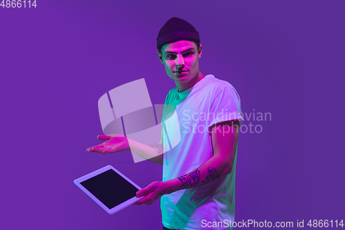 Image of Caucasian man\'s portrait isolated on purple studio background in neon light