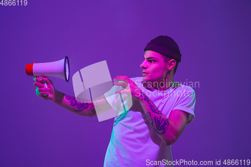 Image of Caucasian man\'s portrait isolated on purple studio background in neon light