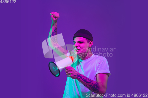 Image of Caucasian man\'s portrait isolated on purple studio background in neon light