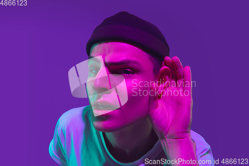 Image of Caucasian man\'s portrait isolated on purple studio background in neon light