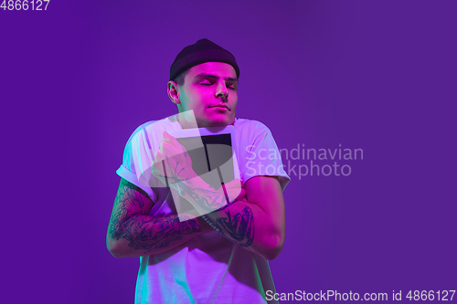 Image of Caucasian man\'s portrait isolated on purple studio background in neon light