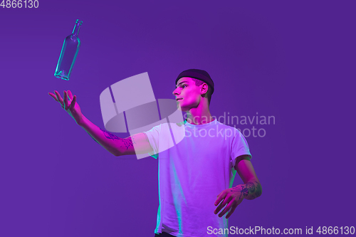 Image of Caucasian man\'s portrait isolated on purple studio background in neon light