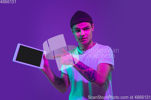 Image of Caucasian man\'s portrait isolated on purple studio background in neon light