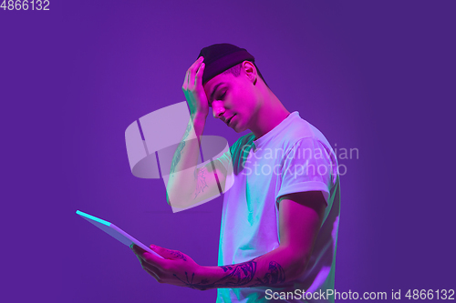 Image of Caucasian man\'s portrait isolated on purple studio background in neon light