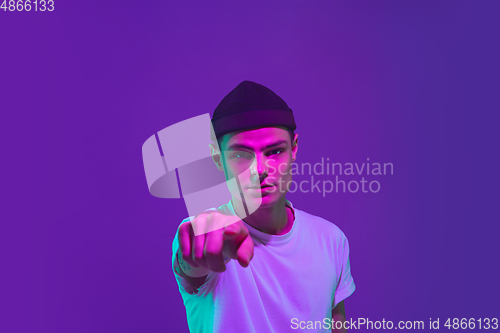 Image of Caucasian man\'s portrait isolated on purple studio background in neon light