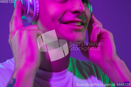 Image of Caucasian man\'s portrait isolated on purple studio background in neon light