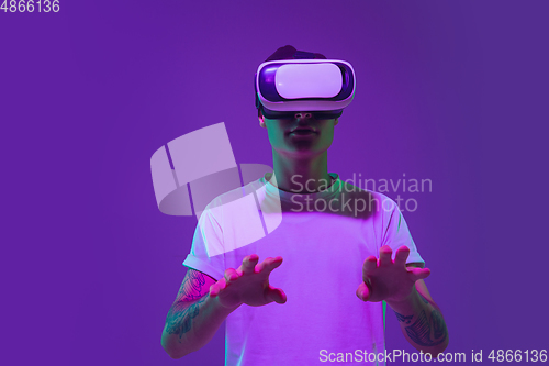 Image of Caucasian man\'s portrait isolated on purple studio background in neon light
