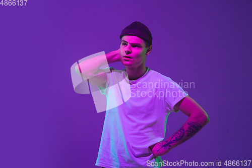 Image of Caucasian man\'s portrait isolated on purple studio background in neon light