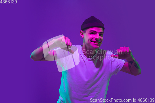 Image of Caucasian man\'s portrait isolated on purple studio background in neon light