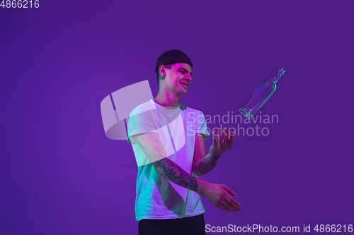 Image of Caucasian man\'s portrait isolated on purple studio background in neon light
