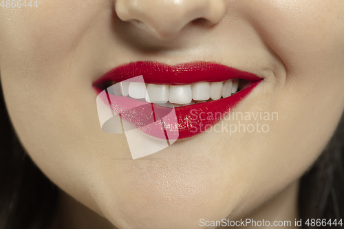 Image of Close-up female mouth with bright red gloss lips make-up. Cosmetology, dentistry and beauty care, emotions