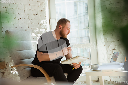 Image of Young man studying at home during online courses for managers, marketers, buyers